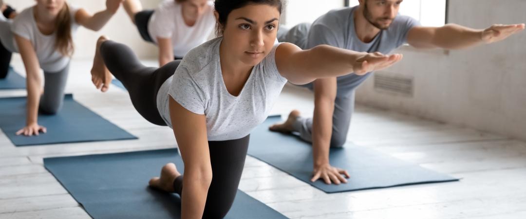 2 women and 2 men stretching on yoga mats