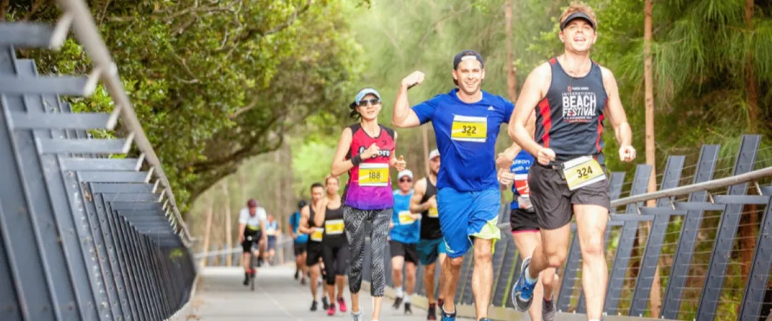 Runners running along path lined with trees