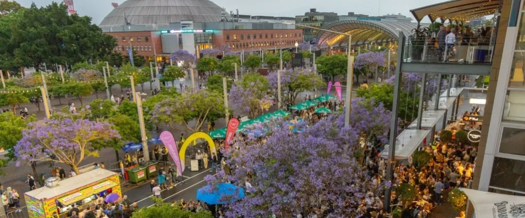 People outside a stadium with food trucks