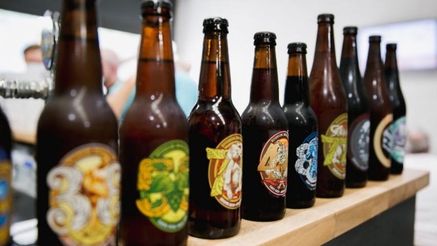 bottles of beer lined up on a bar