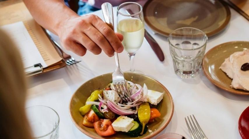 person picking up greek salad with a fork