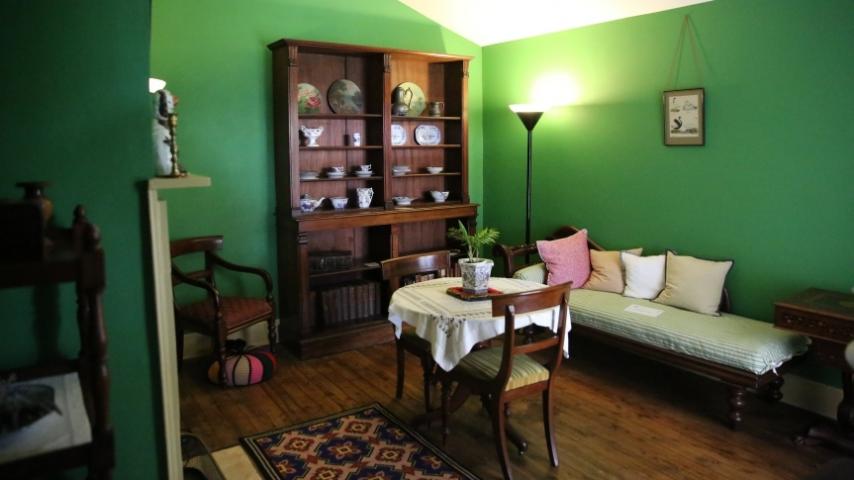 green room at elizabeth farm with sofa and table and chairs and a bookcase