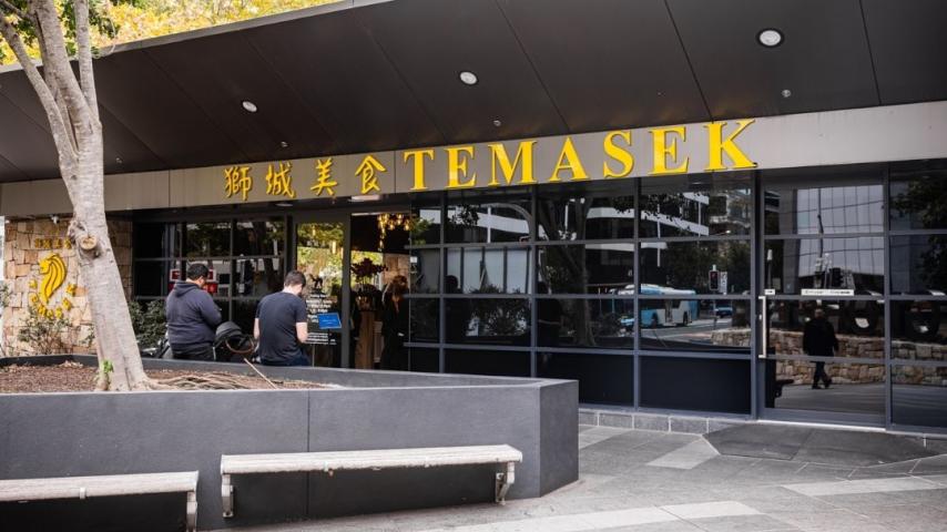 Grey modern building with large windows. Writing on building in yellow 'Temasek'