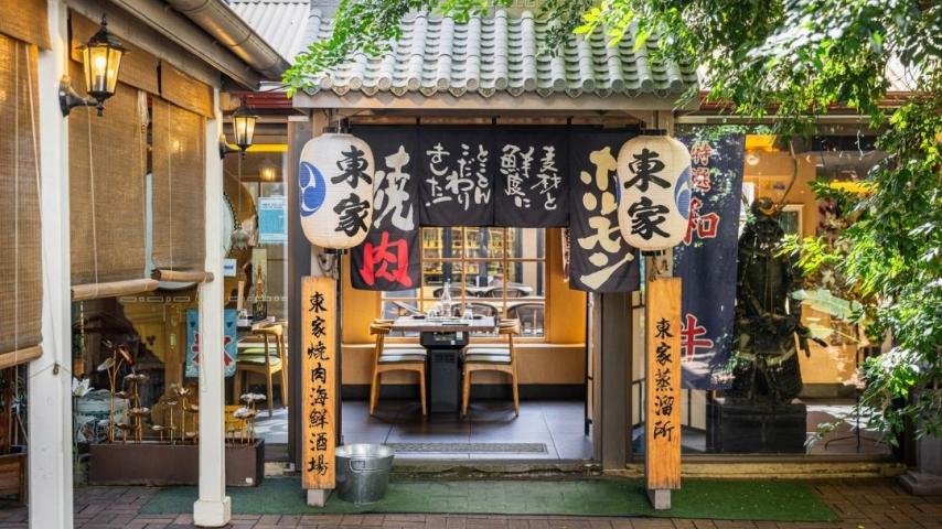 Arch way with Japanese writing down the sides leading into restaurant 