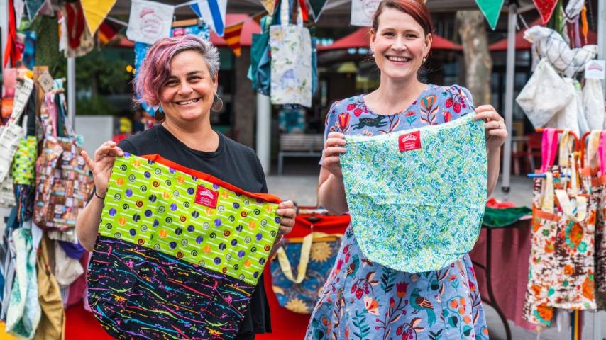 Two ladies holding hand sewed bags 